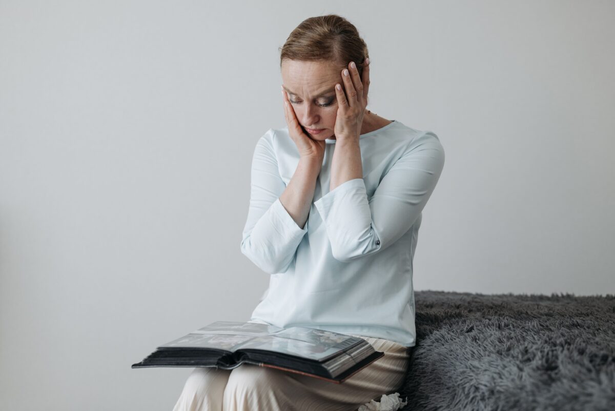 Are You Curious Why Your Heart Suddenly Races? Here Are 19 Reasons Why 5 woman-looking-at-photo-albums-with-hands-on-face