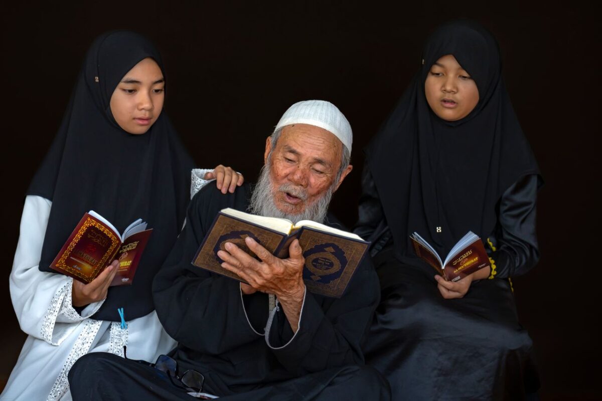 /elderly-man-and-girls-reading-religious-text-