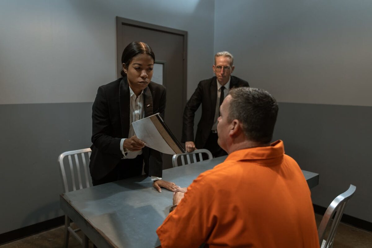 man-in-black-suit-jacket-standing-beside-man-in-orange-dress-shirt-
