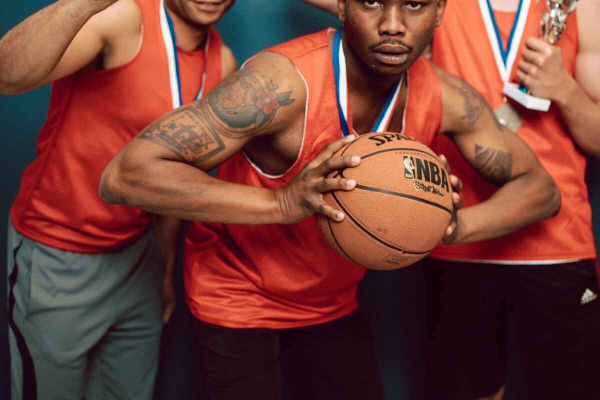 basketball-players-wearing-uniform-holding-ball-and-trophy