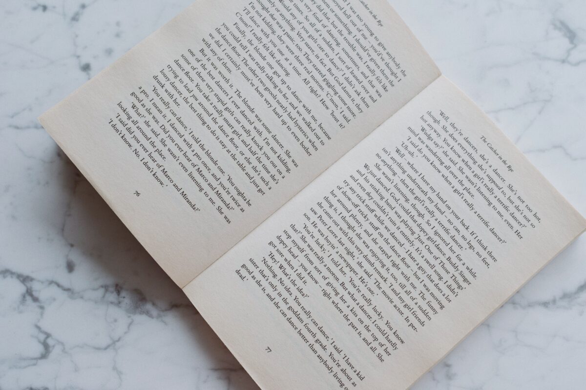 opened-book-lying-on-marble-desktop