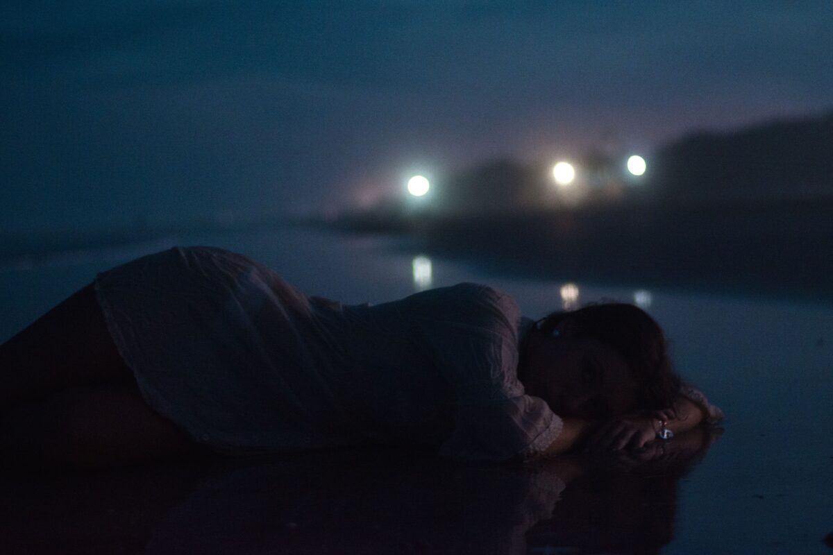 woman-lying-down-on-pavement-at-night-and-sleeping