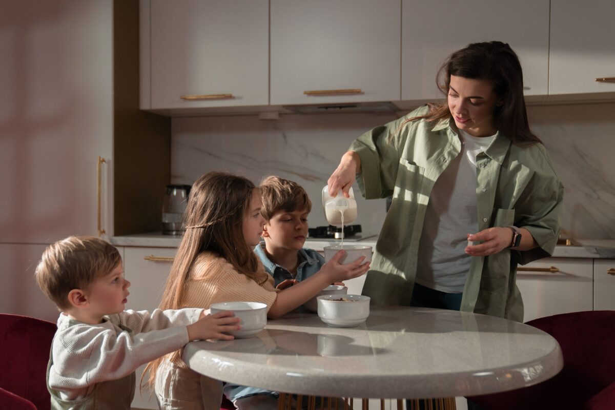 a-mother-pouring-milk-on-her-daughter-s-bowl