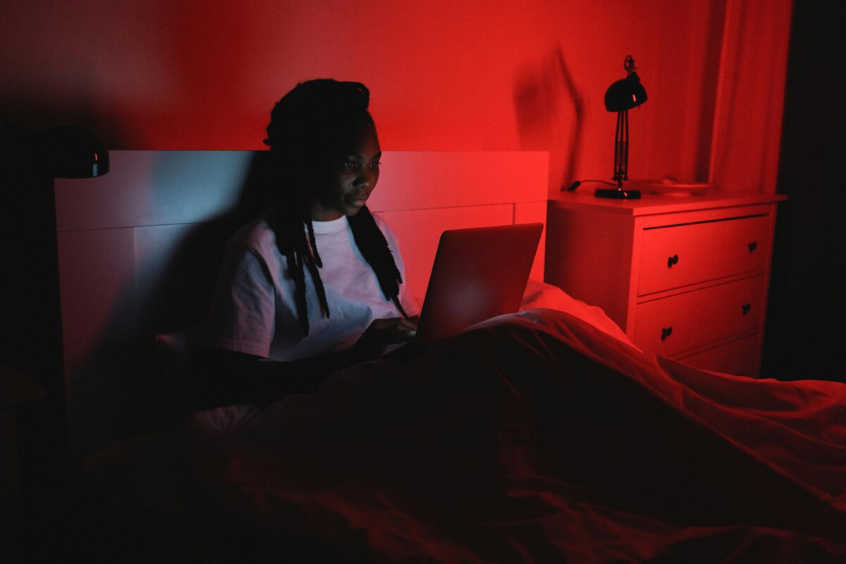 woman-sitting-on-bed-while-using-a-laptop