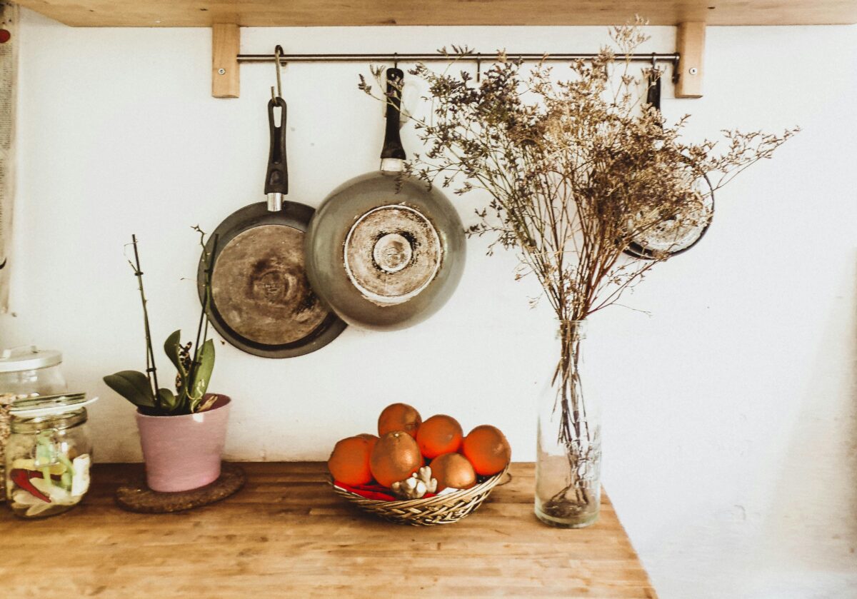 two-gray-frying-pans-hanging-on-wall