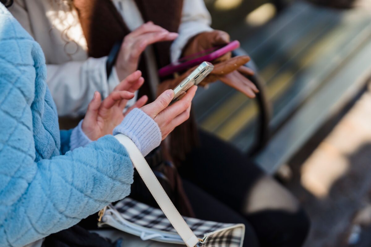 8 Sad Ways Being Online Is Ruining Real-Life Friendships 1 women-touching-screens-of-smartphones-in-park