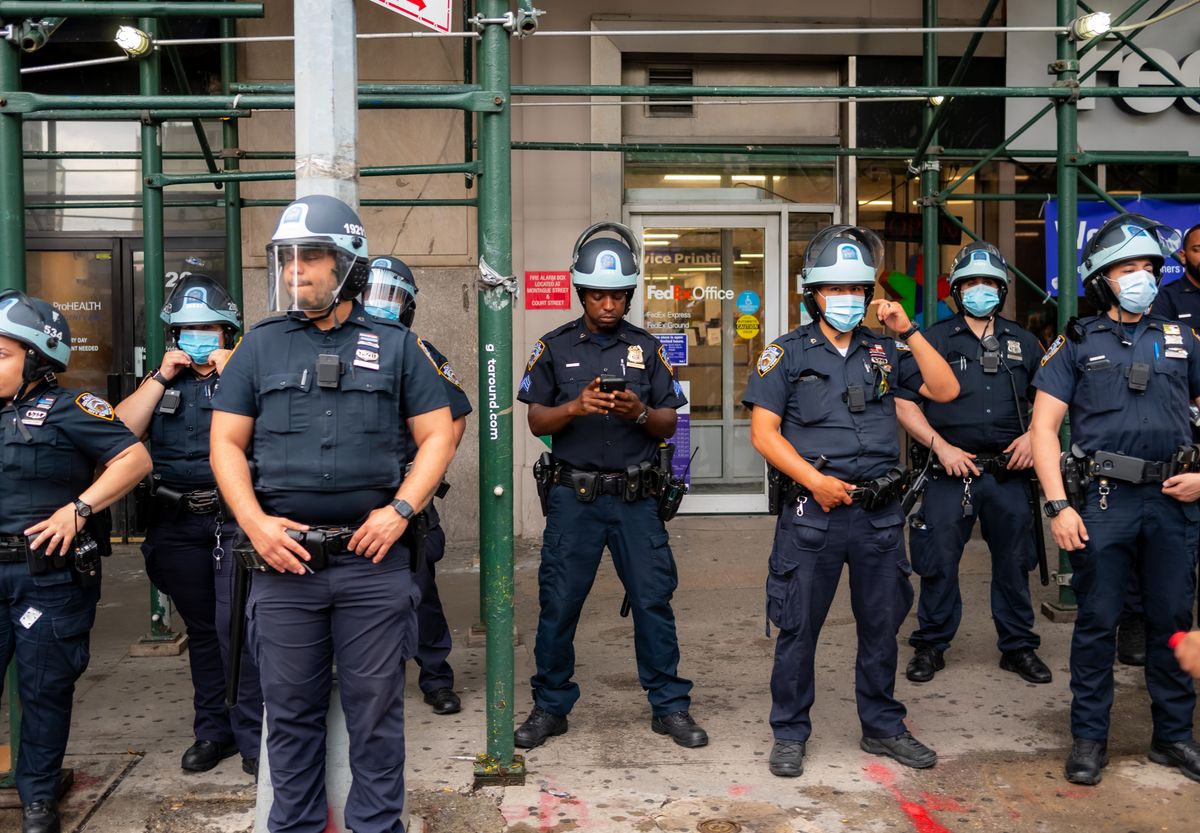 Mother Allegedly Leaves 13-Year-Old in Vehicle for Food Pickup, Returns to Find Six Police Officers Waiting 2 Police officers in full uniform and helmets stand in urban setting, ensuring public safety.