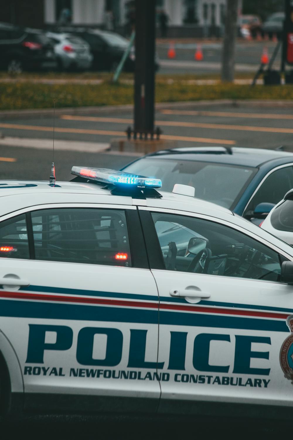 Royal Newfoundland Constabulary police car parked on a city street with blue and red lights.