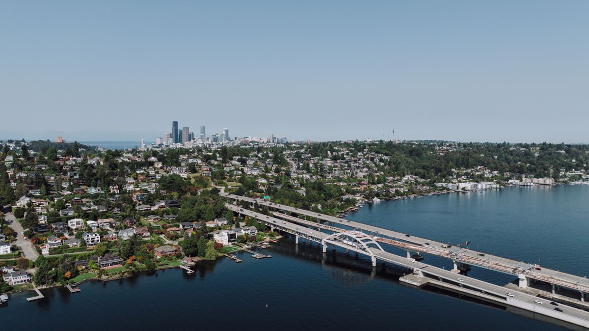 D.C.’s $21 million affordable housing fight exposes a brutal question: Who pays when a building falls apart? 1 Scenic aerial shot of Seattle skyline with bridge spanning across a lake on a clear day.