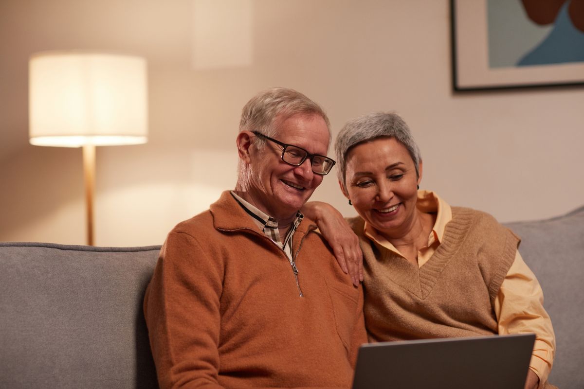 10 Social Security Mistakes Women in Their 50s Should Fix Before Retirement Gets Expensive 1 Senior couple enjoying time together on laptop indoors, smiling and relaxed.