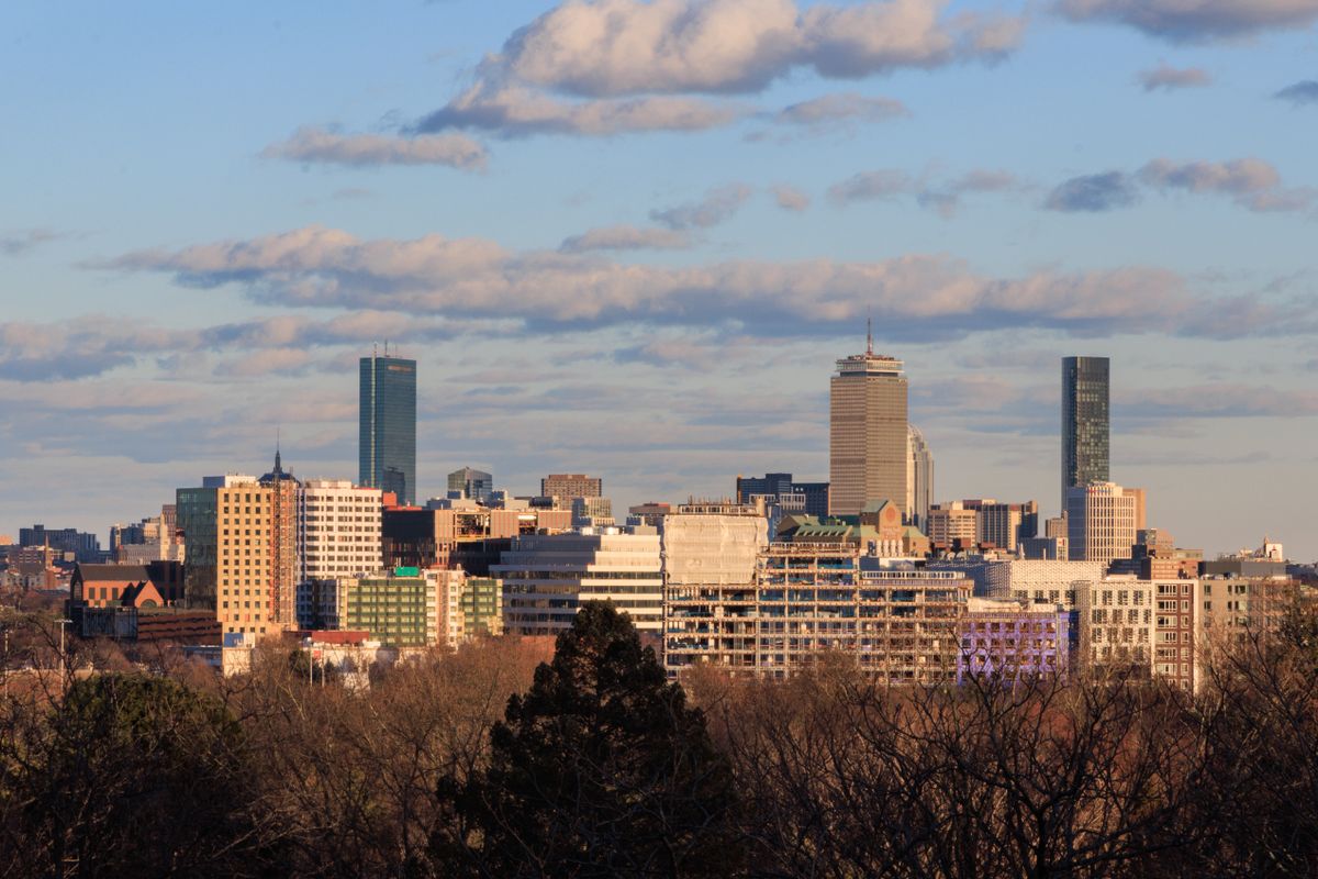 Skyline view of Cambridge, Massachusetts with Boston cityscape in the background under a clear sky.