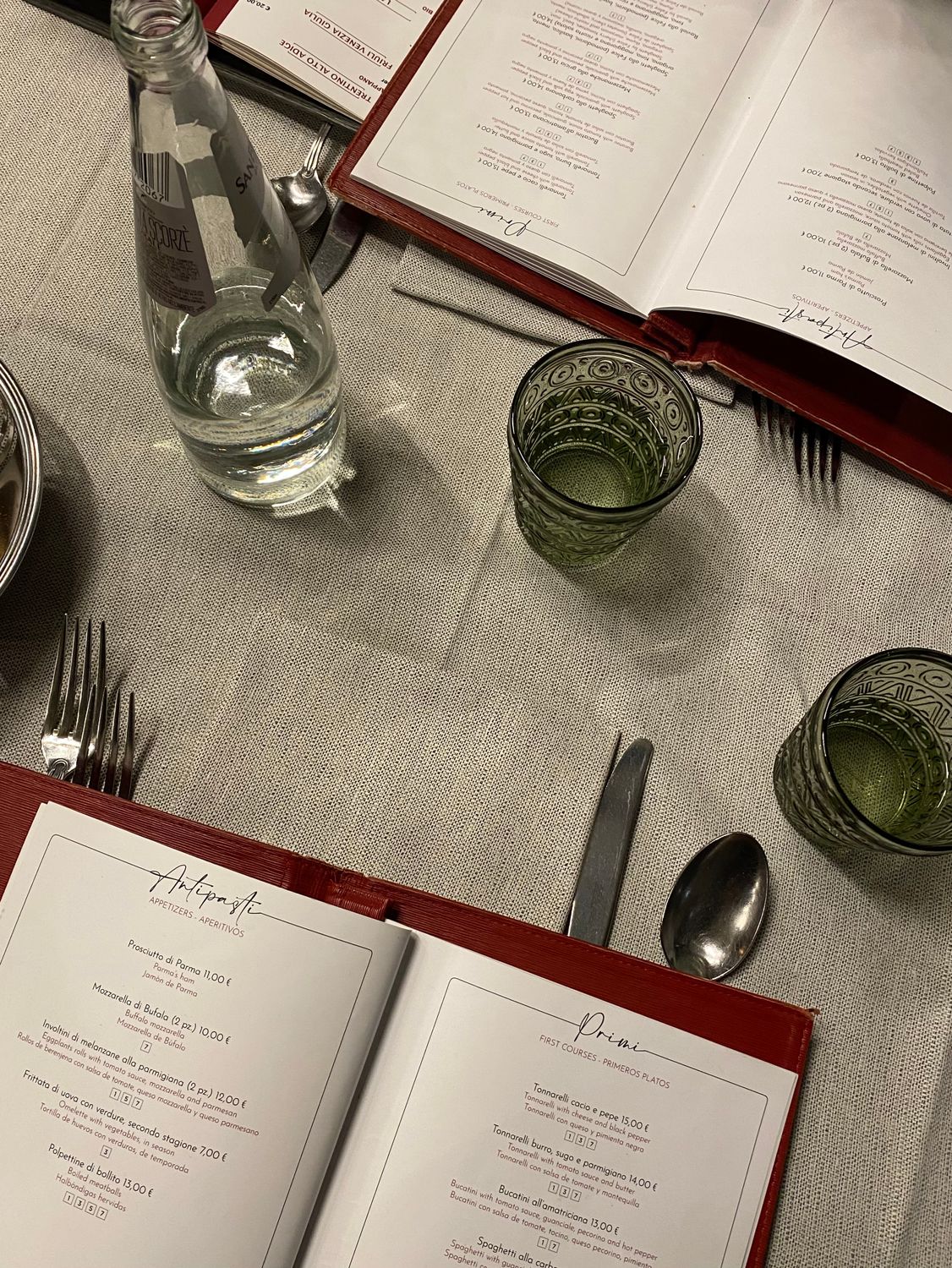 NYC and New Jersey’s Ultimate Food Scene: Where Every Bite Tells a Story 4 Sophisticated table setting in a Roman restaurant with menus and water bottle, perfect for dining in Italy.