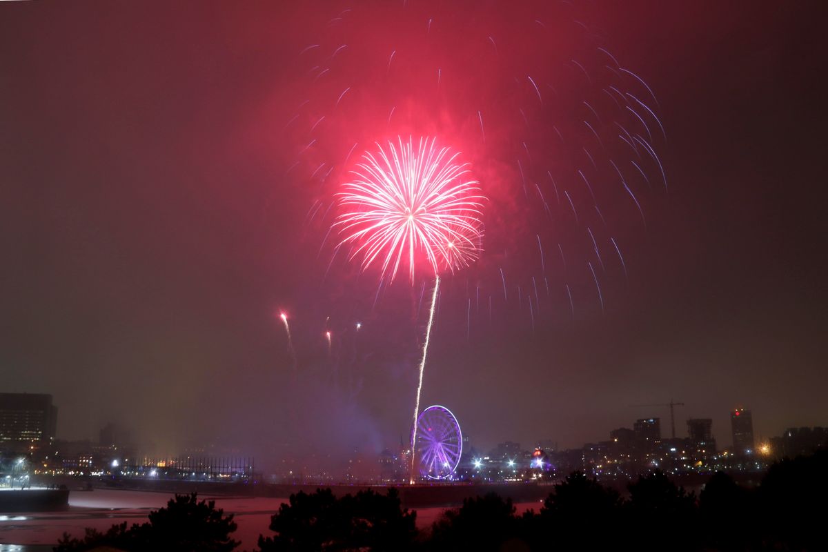 Spectacular fireworks illuminate the night sky above the city skyline, offering a breathtaking celebration view.