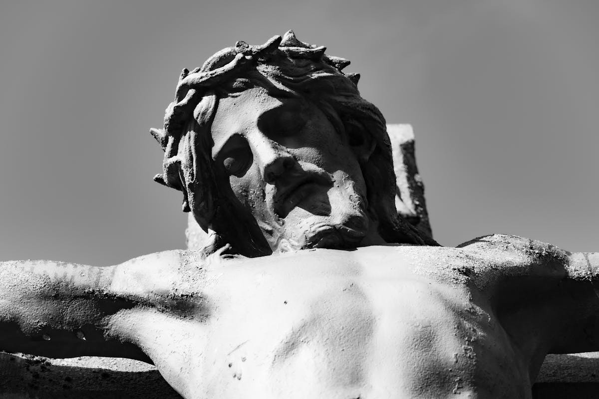 10 Reasons Jesus Kept the Scars That Death Couldn’t Erase 1 Stark black and white image of Jesus Christ crucifixion statue, symbolizing faith and sacrifice.