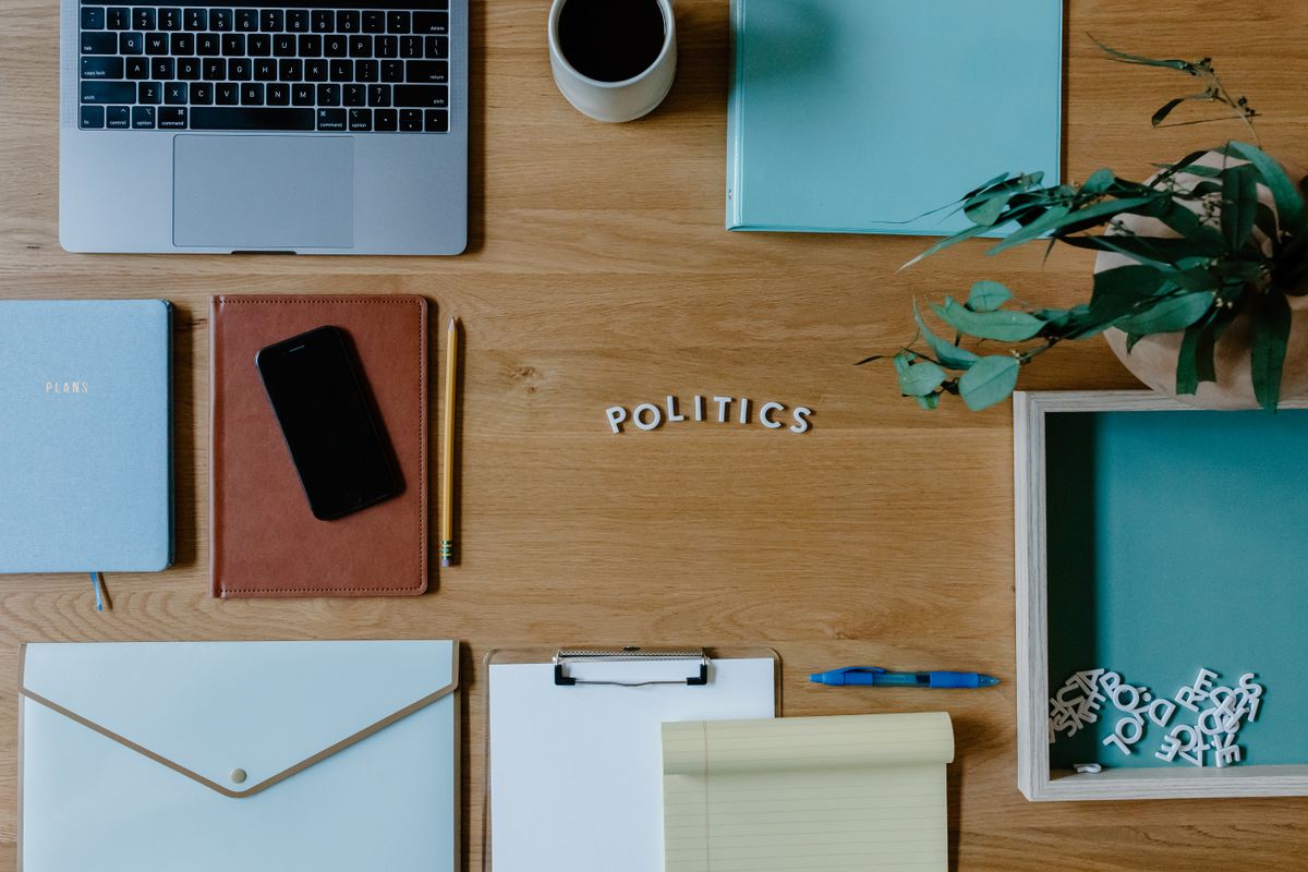 Stylish flat lay of office workspace featuring political themes and modern accessories.