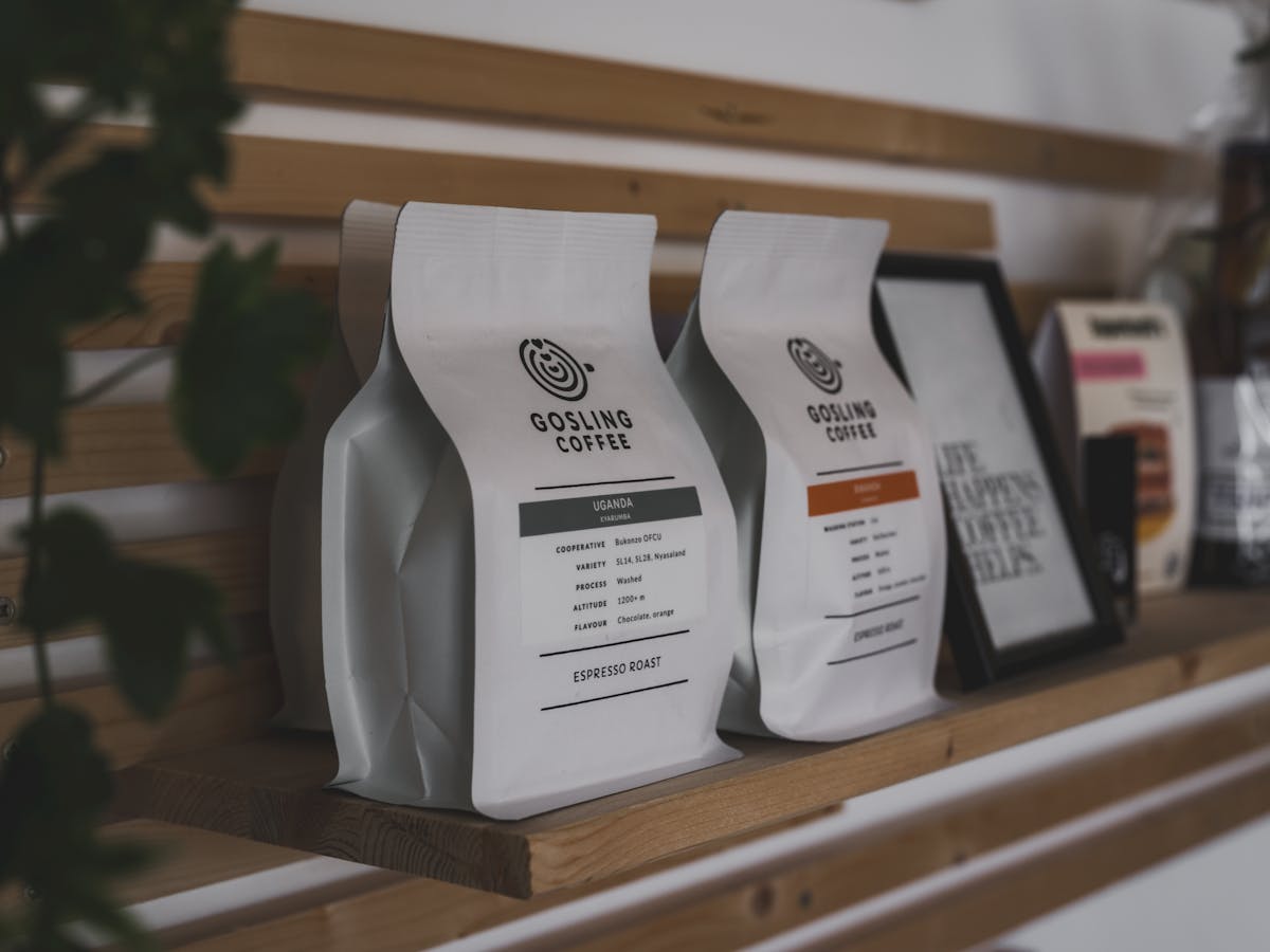 Grocery Prices Are Out Of Control: 10 Items to Grab Before Costs Soar Again 2 Stylish showcase of Gosling Coffee packaging with wooden accents on a shelf indoors.