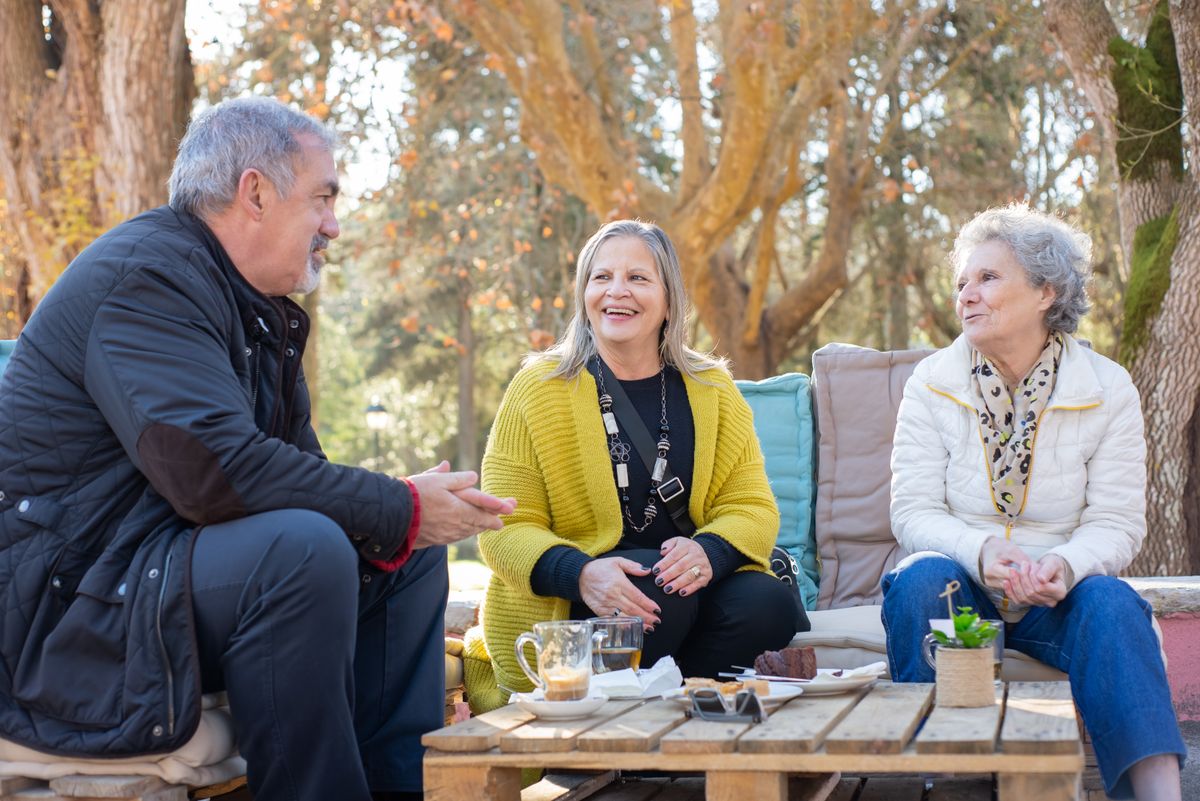 12 Routines Retirees Can Incorporate Into Their Lives To Help Kill Boredom 3 Three senior adults enjoying tea outdoors on a wooden table in Portugal's forest park.