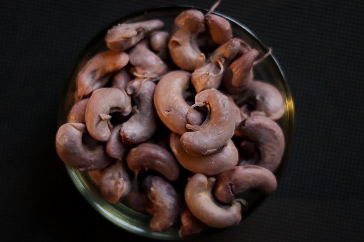 Top view of raw cashew nuts piled in a bowl, perfect for food and ingredient themes.