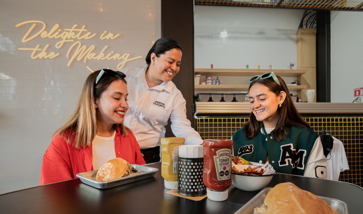 America’s Best Burger Chain Ranking Shows Why In-N-Out Beats McDonald’s, Burger King, and Wendy’s 1 Two friends enjoying burgers and fries at a trendy restaurant with a friendly waitress.
