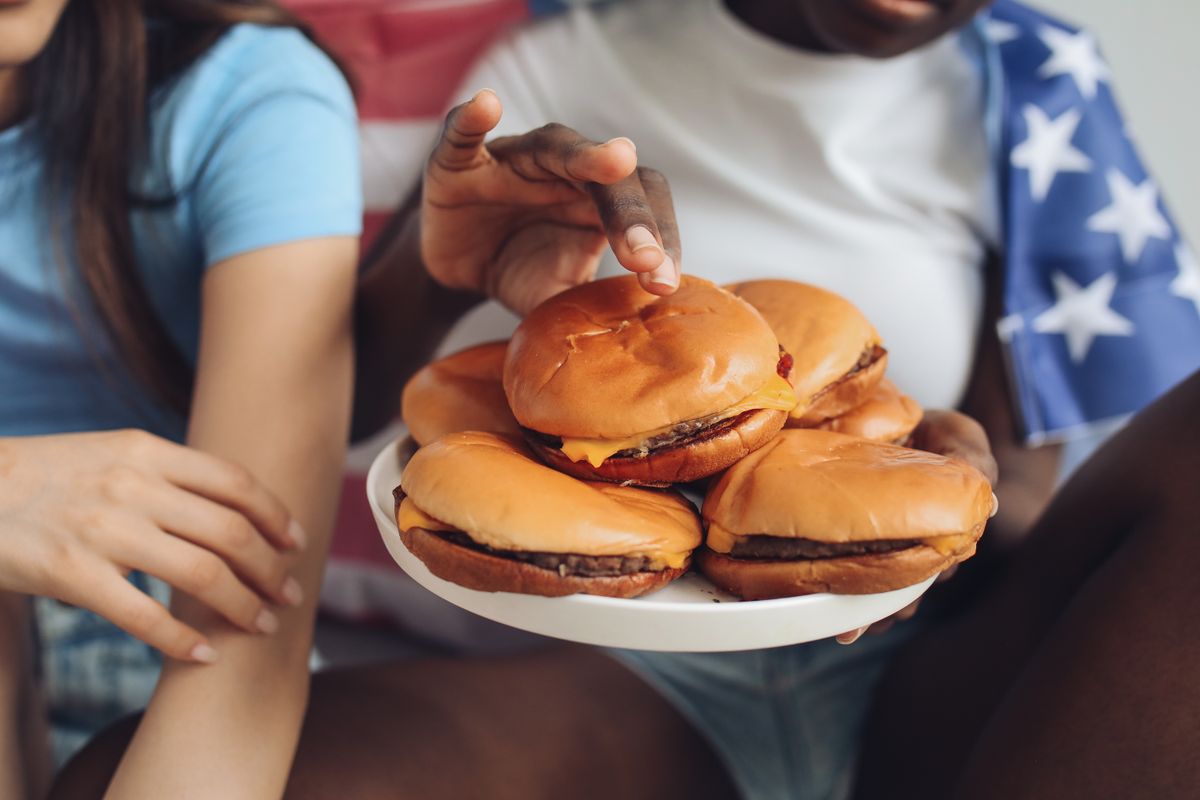 America’s Best Burger Chain Ranking Shows Why In-N-Out Beats McDonald’s, Burger King, and Wendy’s 2 Two people enjoying burgers, symbolizing a casual Independence Day celebration.