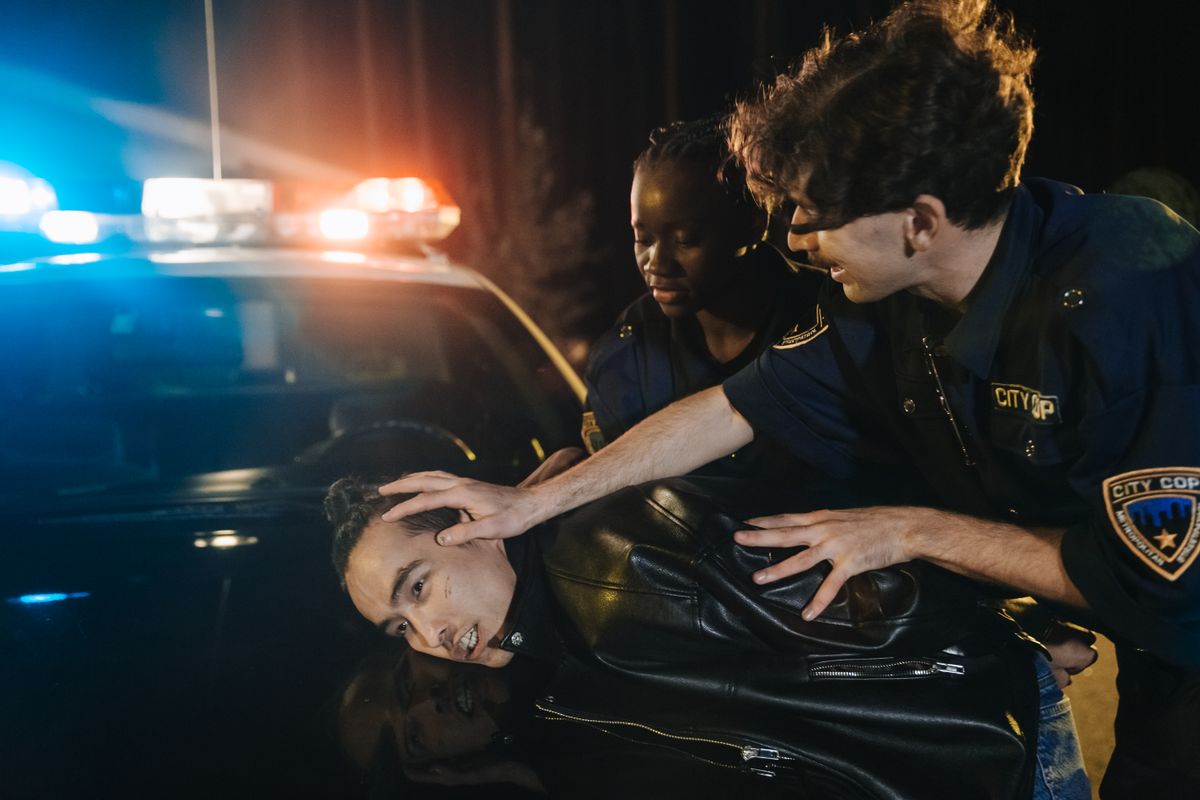 Teens Dominate Florida’s Youth Gun Crime Statistics. 1 Two police officers arrest a suspect during a nighttime operation with flashing lights.