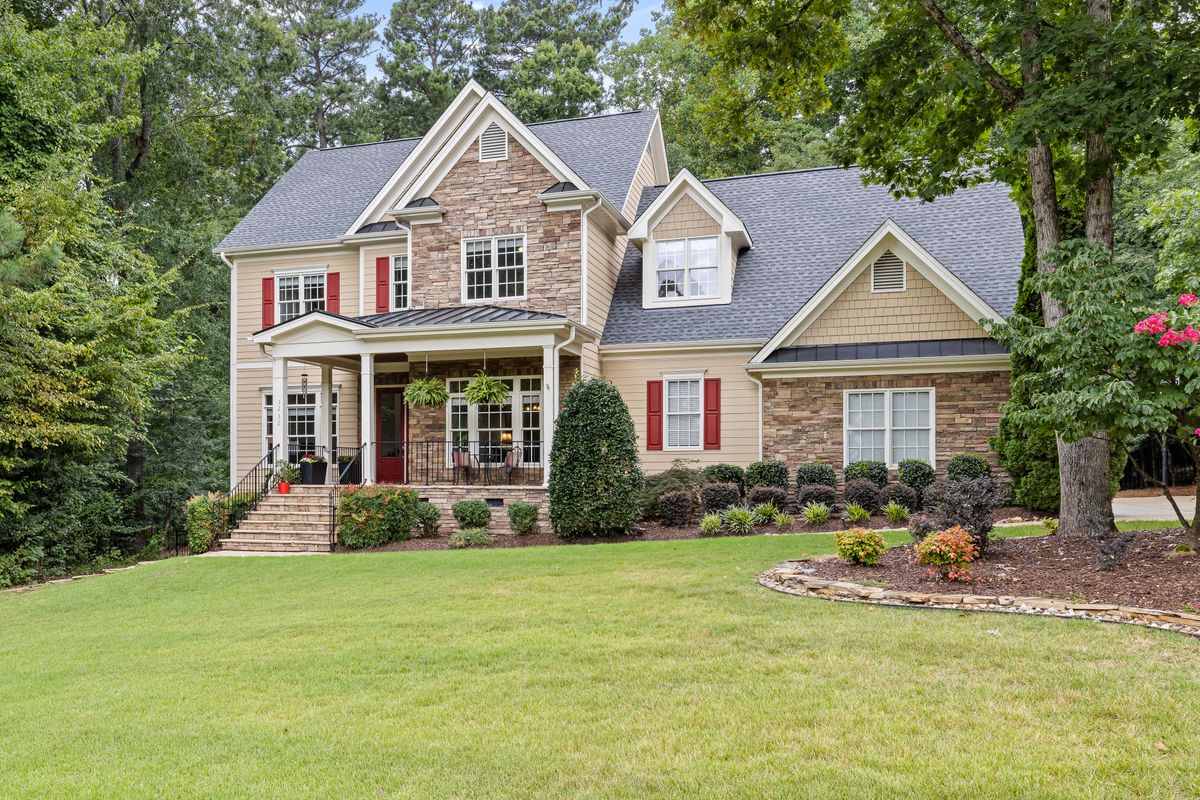 Atlanta Housing Market Sends Warning Signals as Demand Cools Sharply 1 Two-story house surrounded by lush greenery and well-maintained lawn.