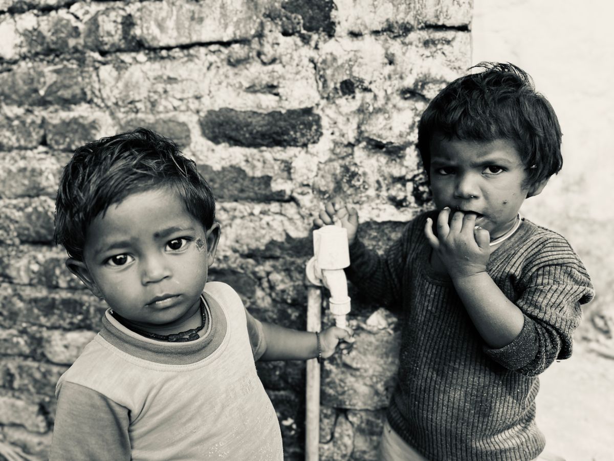 Florida’s Child Hunger Crisis Explodes in 2026: Over 800,000 Kids at Risk 1 Two young children stand by a brick wall, capturing a moment of thoughtful innocence.