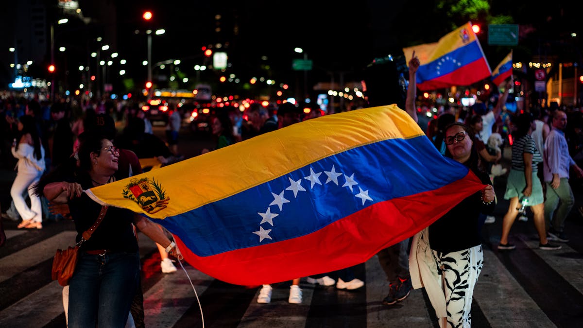 8 World’s Most Corrupt Nations Right Now 2 Venezuelans celebrating with national flags on a busy street in Buenos Aires at night.