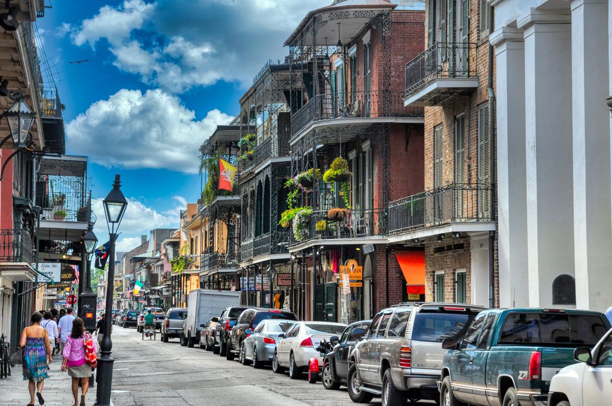 7 Most Miserable States to Live in America in 2026 4 Vibrant day in New Orleans' French Quarter with people walking and historic architecture lining the street.