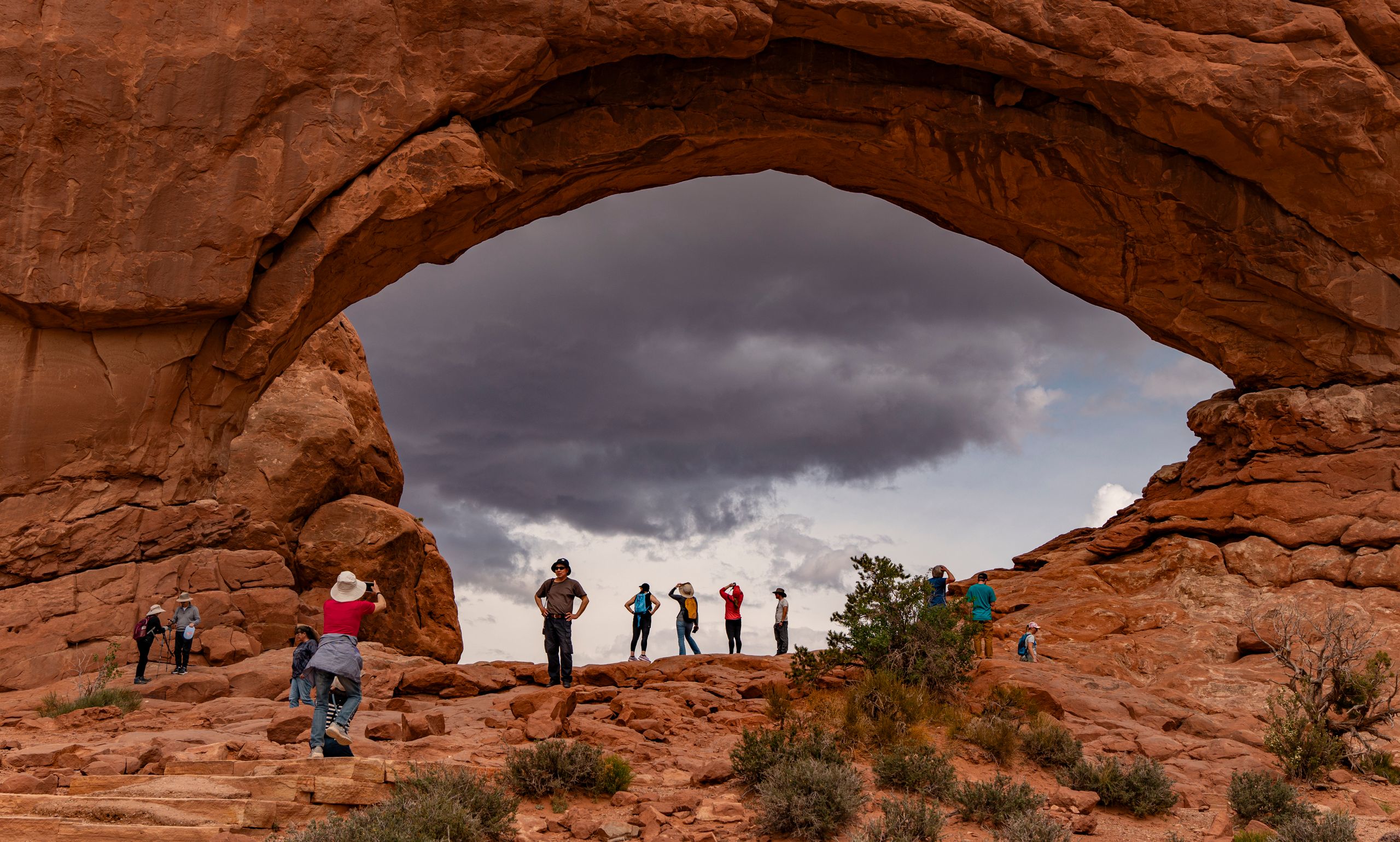 Visitors admire stunning rock formations at Arches National Park.