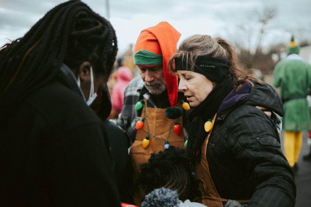 10 Harshest Places People Call Home 4 Volunteers in festive attire helping distribute winter essentials in an urban setting.