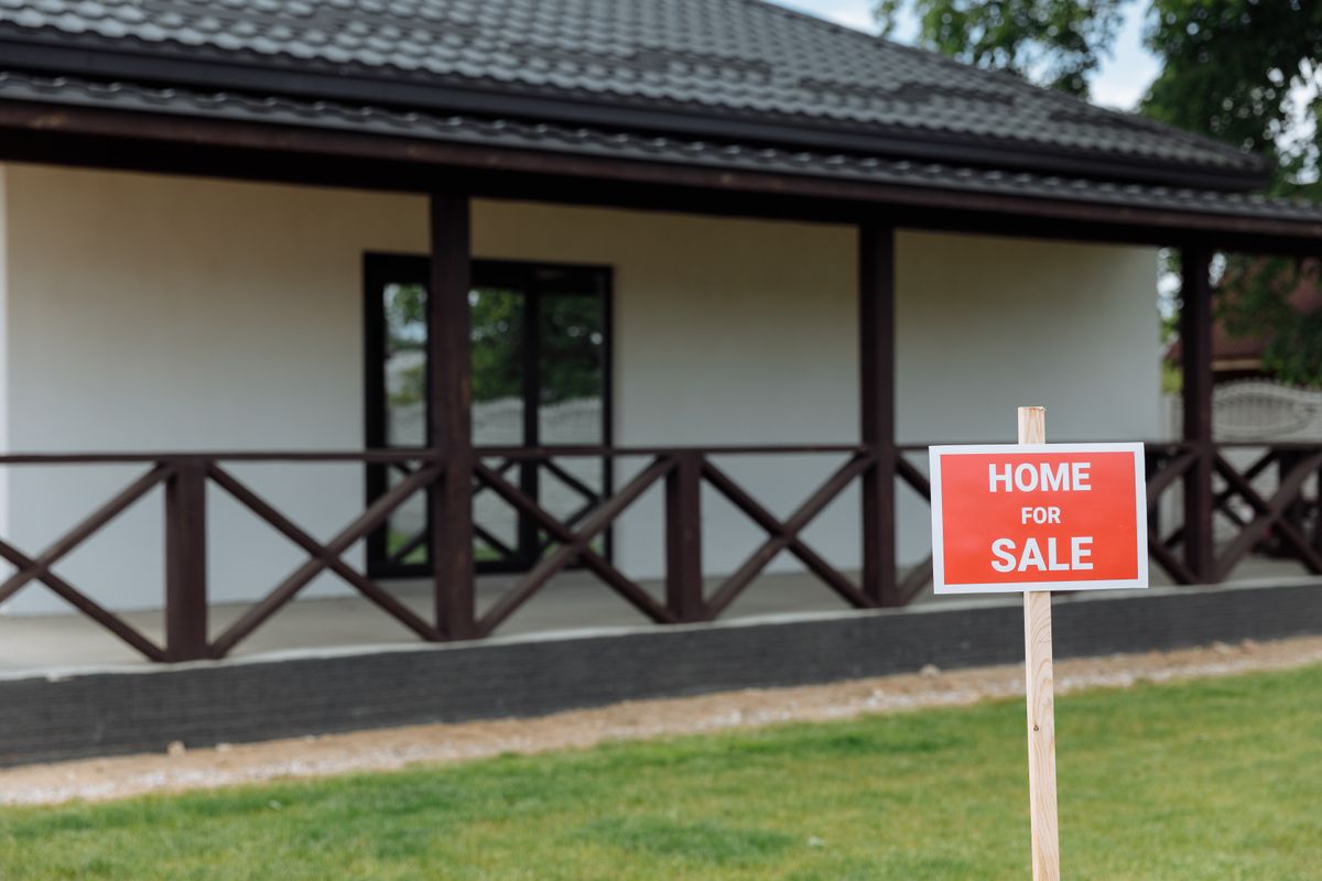 Americans’ Homeownership Preference Rises for First Time Since 2023, Report Says as Buyers Reconsider Renting 1 White house with porch and 'Home for Sale' sign on a sunny day.