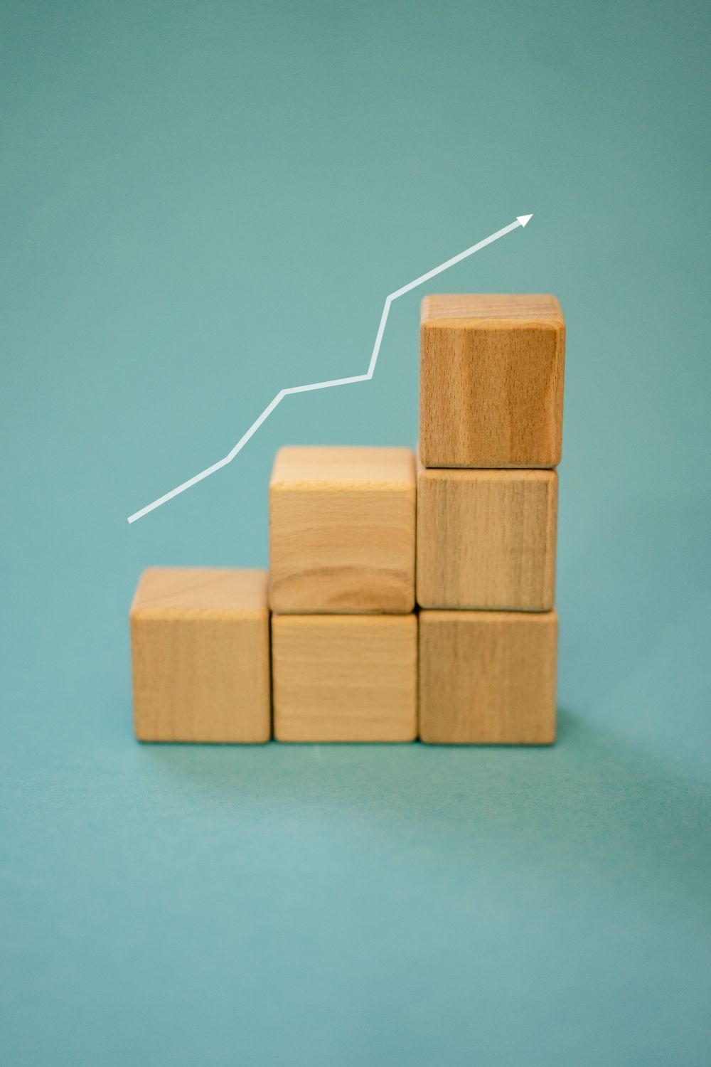 14 Alarming Reasons Five Guys Is Closing U.S. Restaurants 2 Wooden blocks forming a staircase with an upward arrow symbolizing growth and progress.