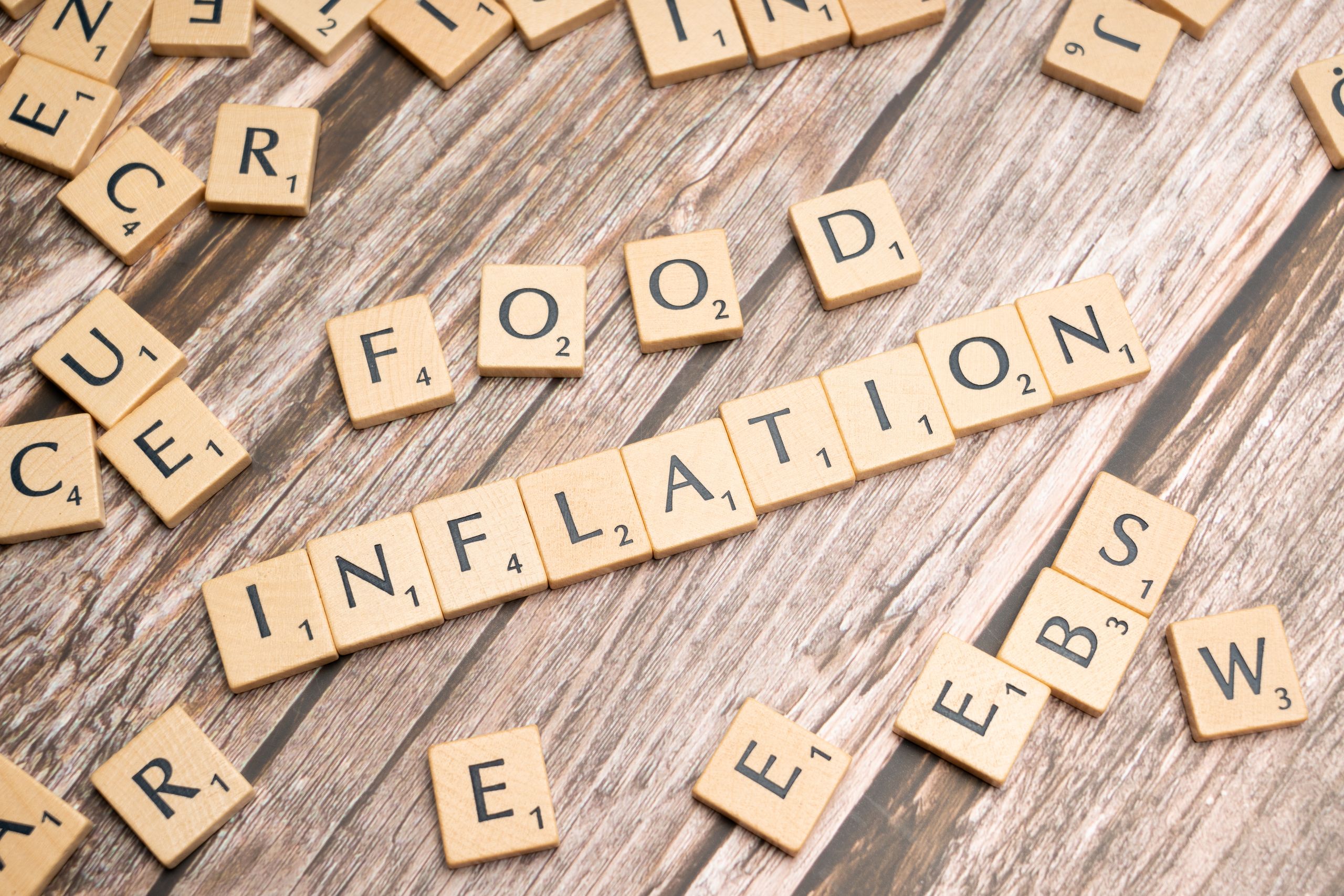 Chain Restaurants Under Pressure in 2026 as Americans Shift Spending and Mid-Tier Dining Takes the Hardest Hit 2 Wooden scrabble tiles arrange to spell 'Food Inflation' on a rustic wooden surface, conceptually depicting rising food prices.