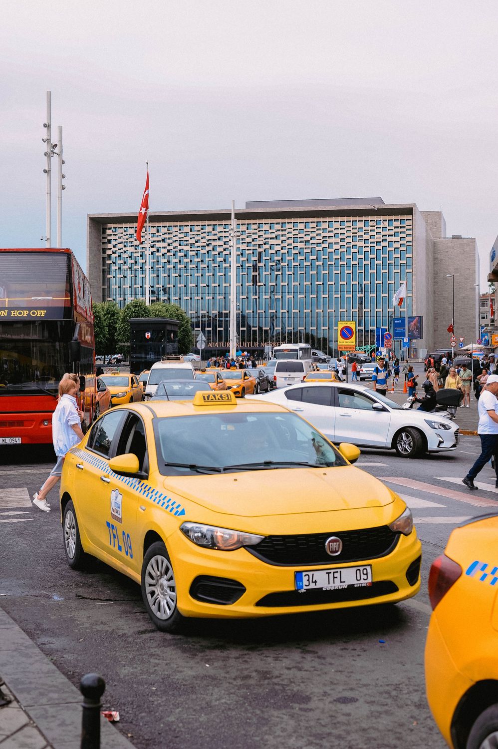 The Cost of Living Calculator Could Be the Reality Check Your Next Move Needs 2 Yellow taxis and bustling street scene in front of a modern building in Istanbul, Turkey.