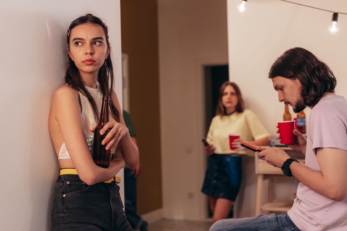 7 Ruthless Signs Someone Is Secretly Sabotaging Your Success 2 Young adults gather indoors enjoying a casual party with drinks and socializing.