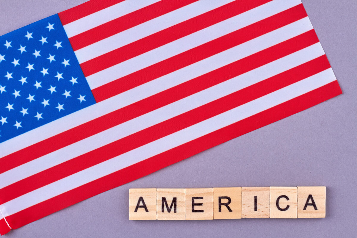 Trump Shared Praise for His Pennsylvania Rally, Then X Revealed the “U.S.” Accounts Were Based Overseas 2 Flag of United States of America. Wooden alphabet blocks with letters isolated on violet background.