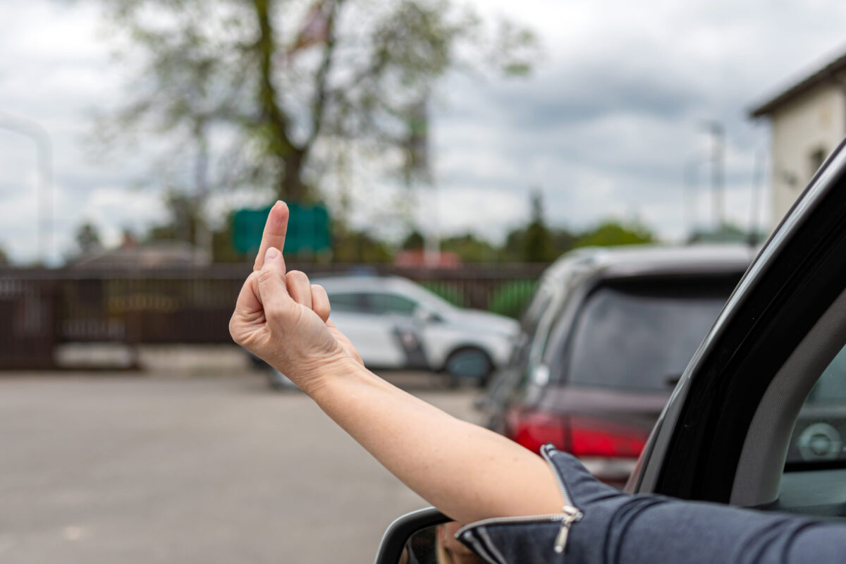 Road Rage Boils Over on William Floyd Parkway as Driver Is Accused of Punching Motorist in Stopped Traffic 1 rude and furious driver giving middle finger to car behind, woman shows obscene gesture from a car