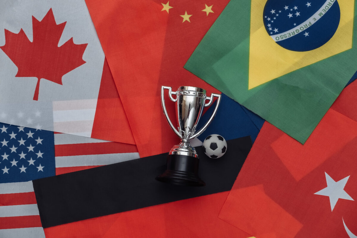 Champion cup with soccer ball on many national flag. Sport competitions