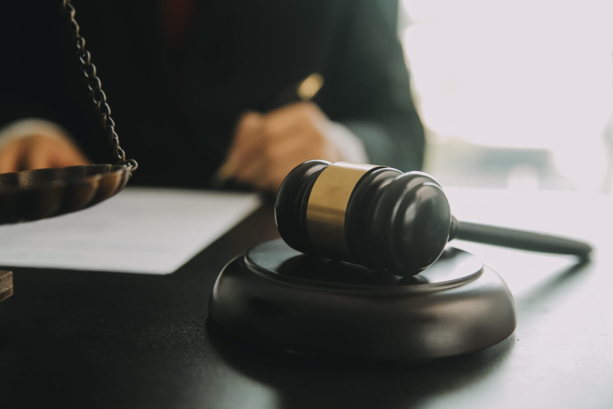 10 Everyday Things Millions of Americans Do That Could Technically Break the Law 1 Justice and Law concept. Legal counsel presents to the client a signed contract with gavel and legal law or legal having team meeting at law firm in background