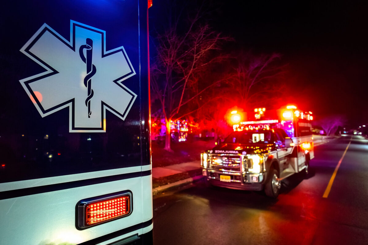 Close up emergency ambulance truck illuminated at night accident response