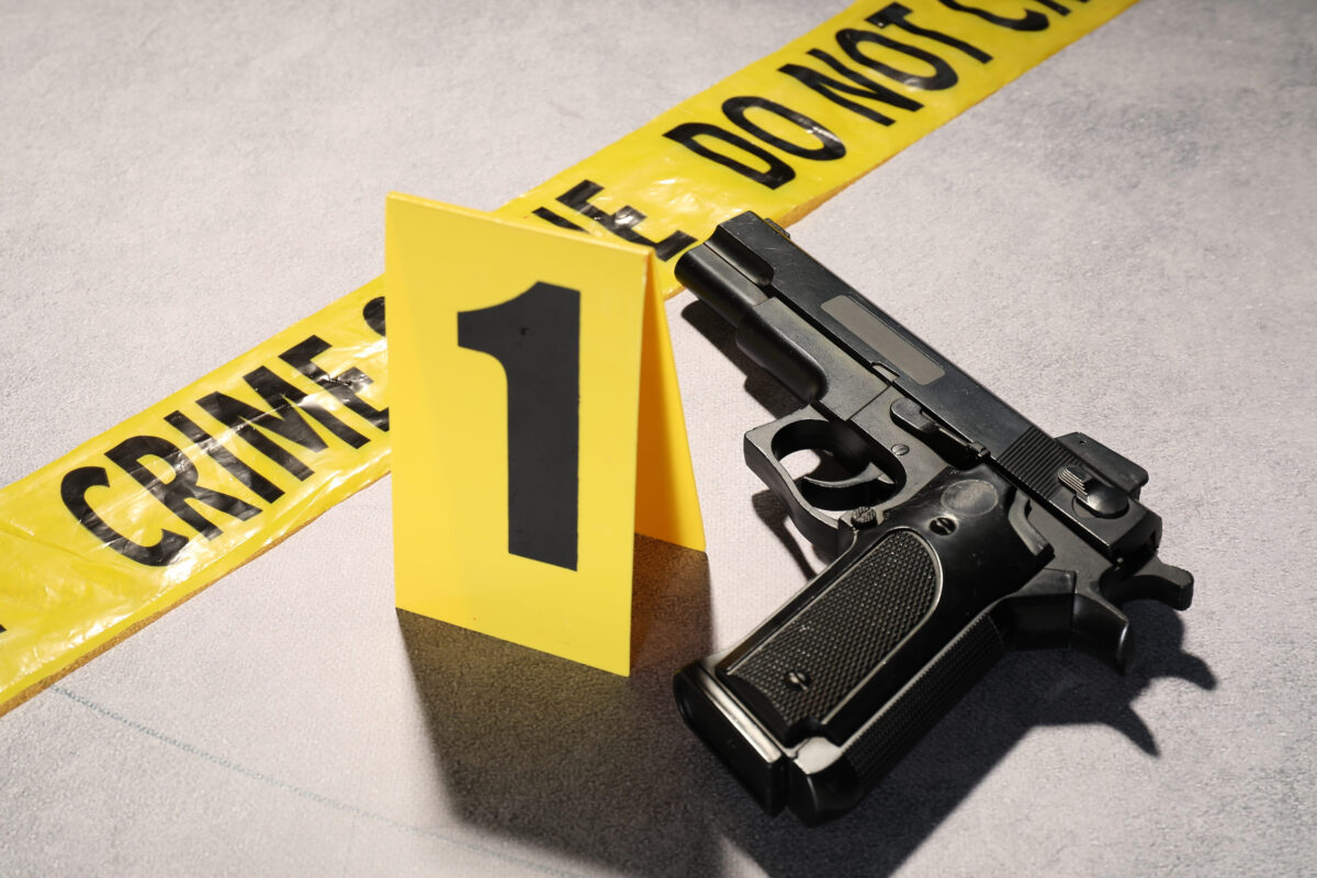 Three Lives Lost Over a $65 Garage Contract; They Were Killed in an Execution-Style Attack, Prosecutors Say 1 Forensic expertise. Crime scene tape and gun on light grey background, closeup