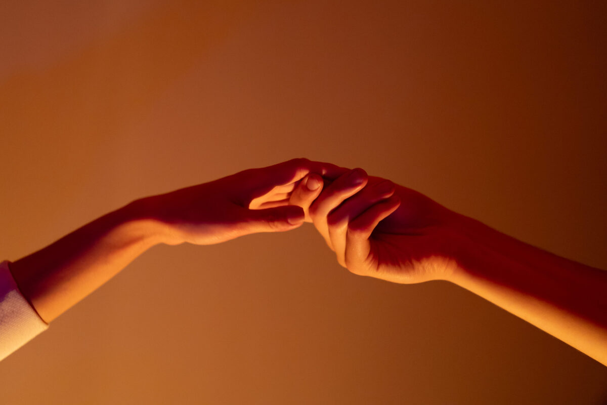 Close-up of a man and a woman hands gently touching, symbolizing connection, unity, and human relationships.