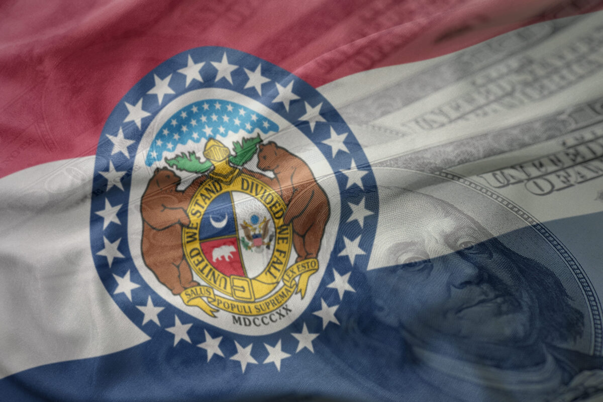 Missouri Draws a Hard Line on Prison Health Spending as Taxpayer-Funded Gender Care Debate Explodes 2 colorful waving flag of missouri state on a american dollar money background. finance concept