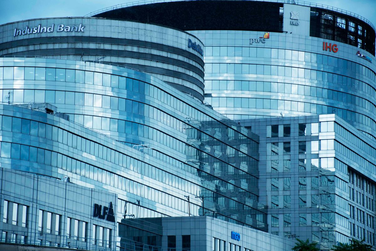 DNC Puts Headquarters on the Line for $15 Million Loan as Debt Overtakes Cash 1 A contemporary glass skyscraper showcasing sleek architecture and corporate logos in an urban setting.
