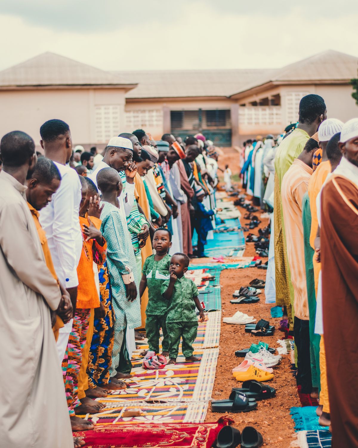 A vibrant gathering of people in colorful attire participating in outdoor prayers in Ghana.