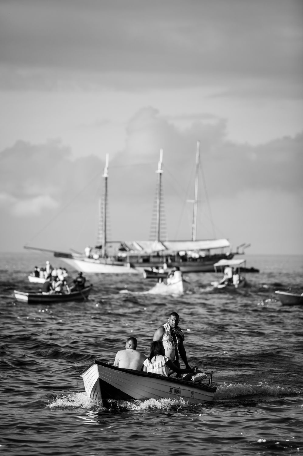 Black and white photo of boats and people on the sea near Bahia, Brazil.