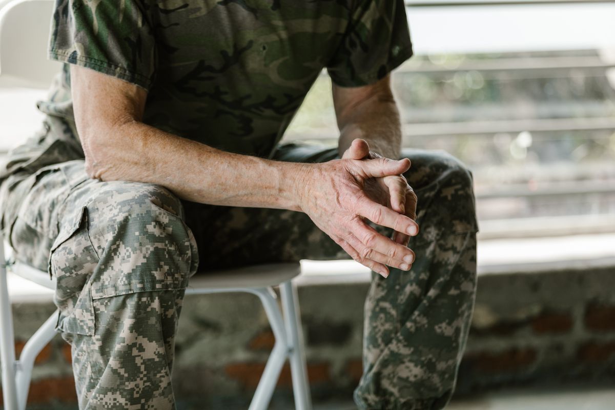 Trump ICE Policy Detains Military Spouses and Parents, Raising Questions About Readiness and Trust 1 Close-up of a military veteran's hands in a therapy session, emphasizing mental health support.