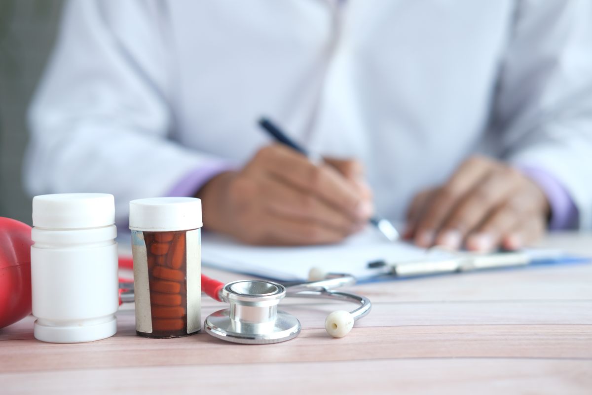 Michigan Parents Charged After 255-Pound 7-Year-Old’s Death Sparks Murder and Torture Case 1 Close-up of doctor writing prescription with medicines and stethoscope on desk.