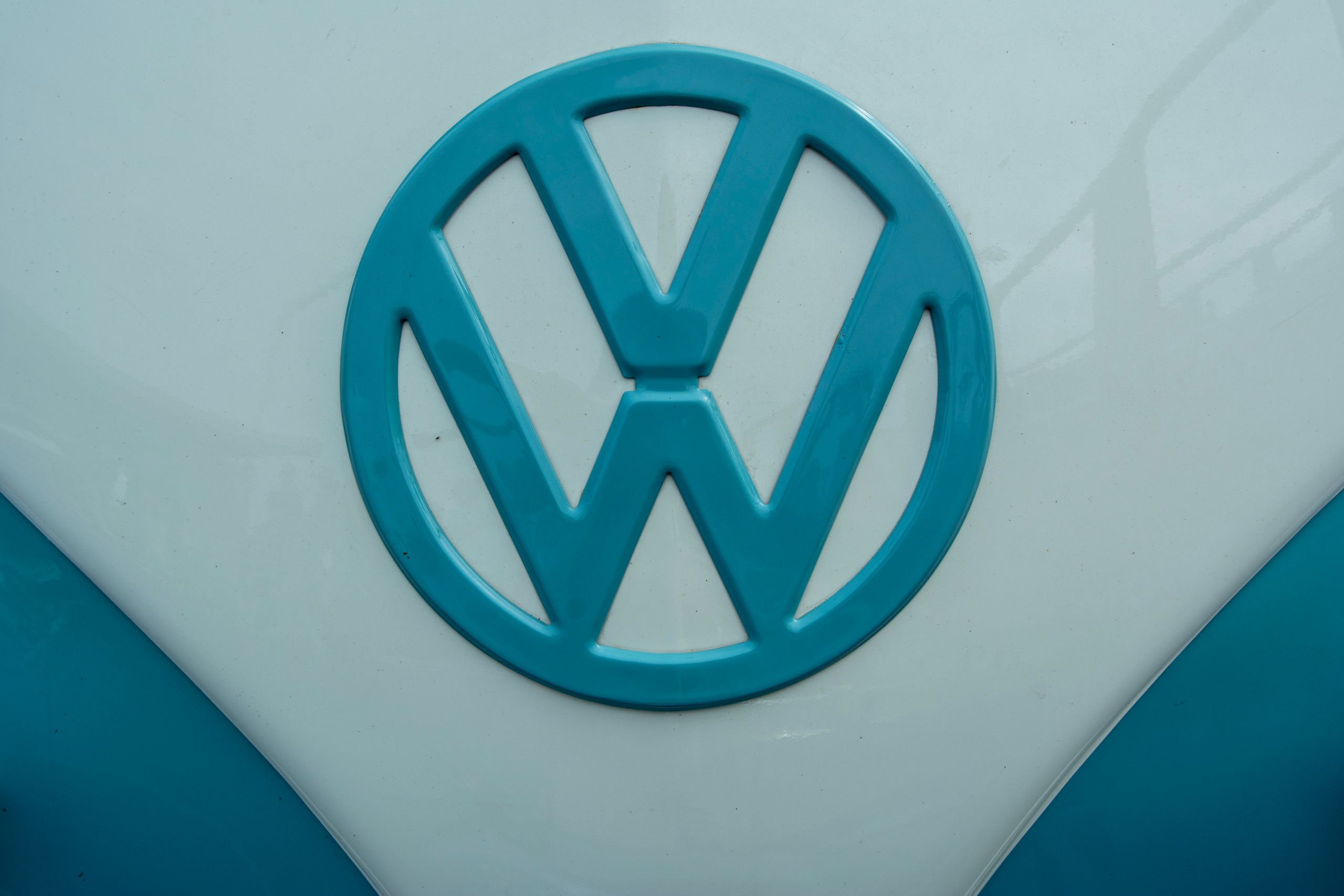 Close-up of the Volkswagen logo on a vintage car hood, showcasing iconic design.